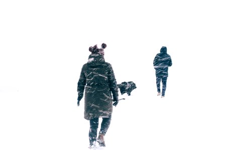photo of two person wearing black jacket walking on snowy weather