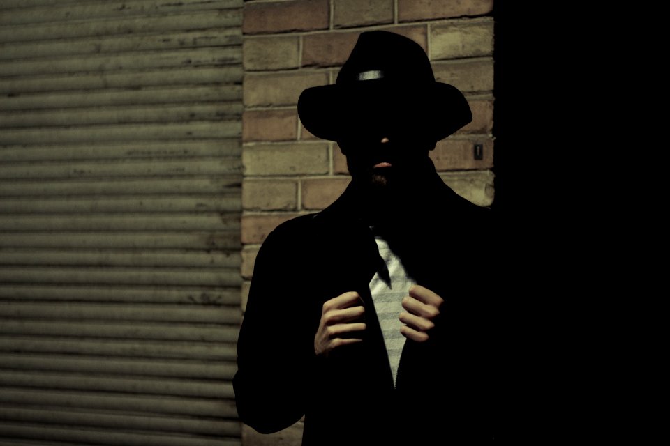 man wearing black fedora hat and black suit jacket
