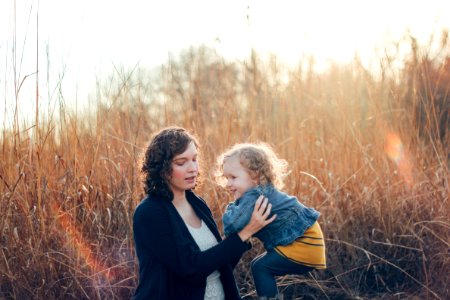 photo of woman carrying girl