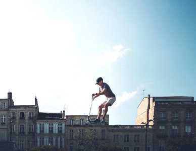 man riding on black kick scooter