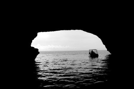 boat on body of water outside the cave photo
