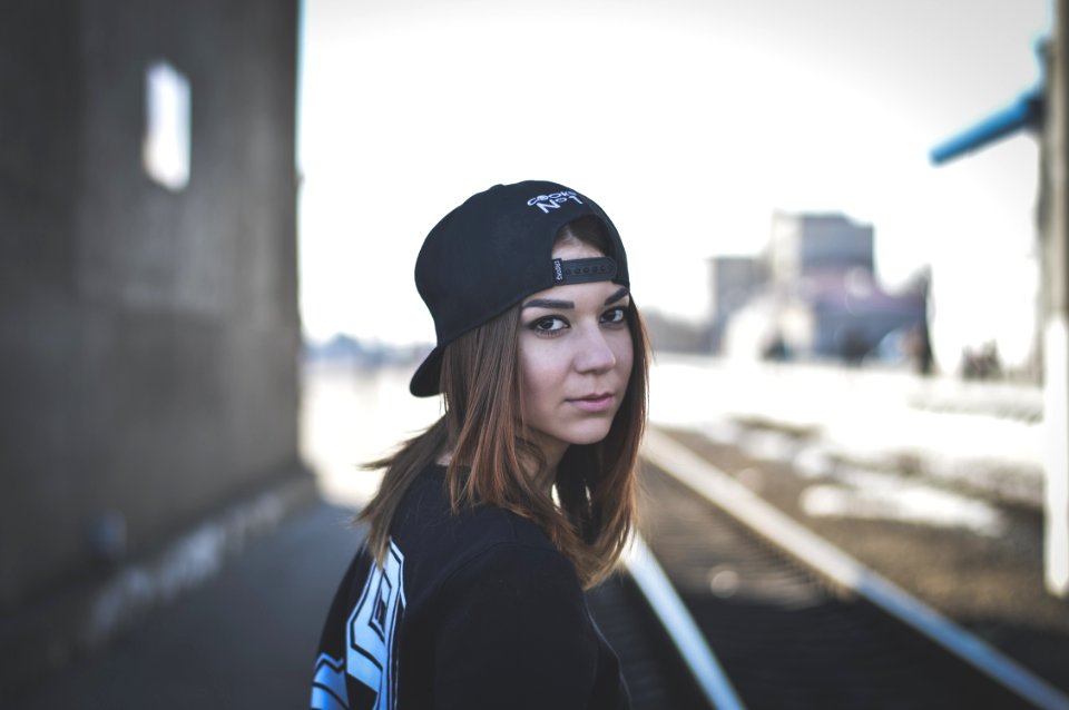 woman wearing black snapback cap looking back