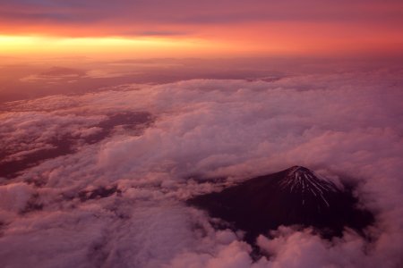 black mountain surrounded with clouds at golden hour photo