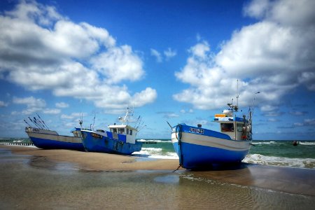 three blue boat docked on seashore during daytime photo