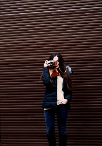 woman standing holding camera taking photo photo