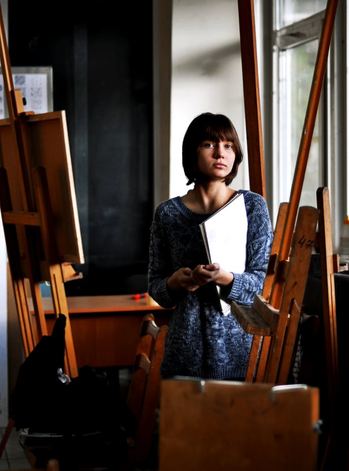 woman holding art book inside art studio