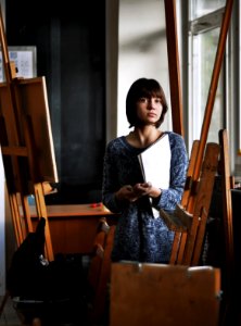 woman holding art book inside art studio