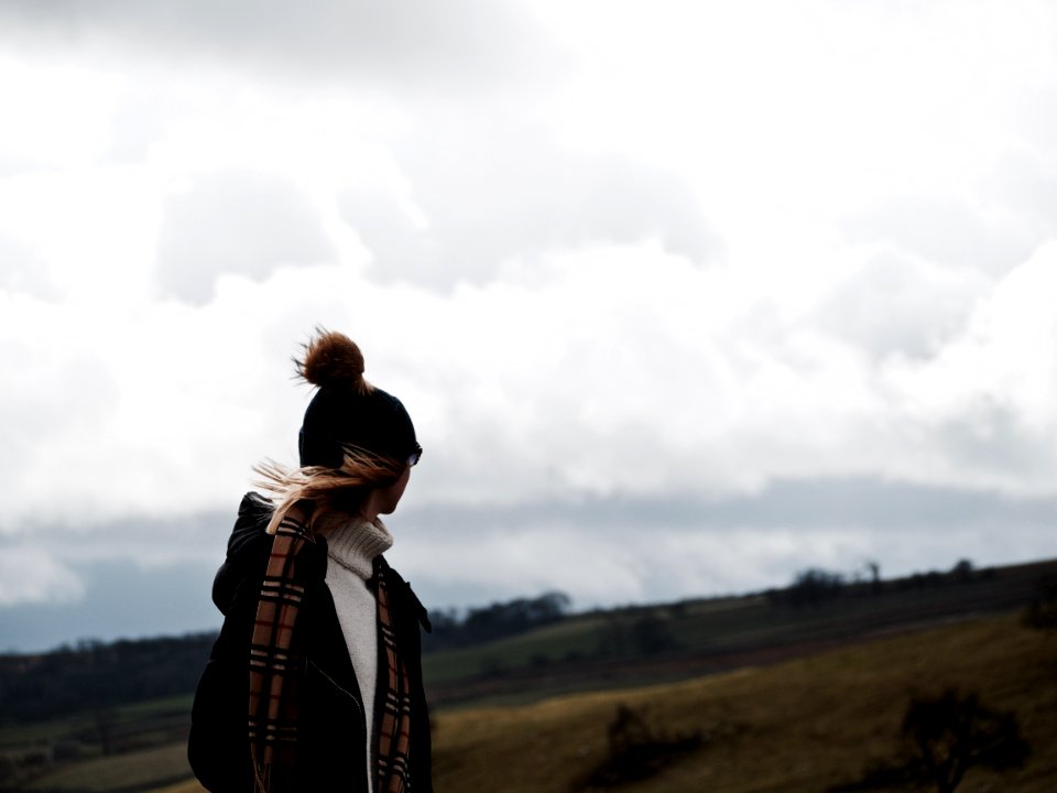 woman looking at back under nimbus clouds photo