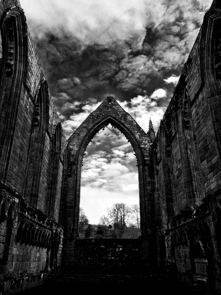 An archway in an alley between two old buildings.