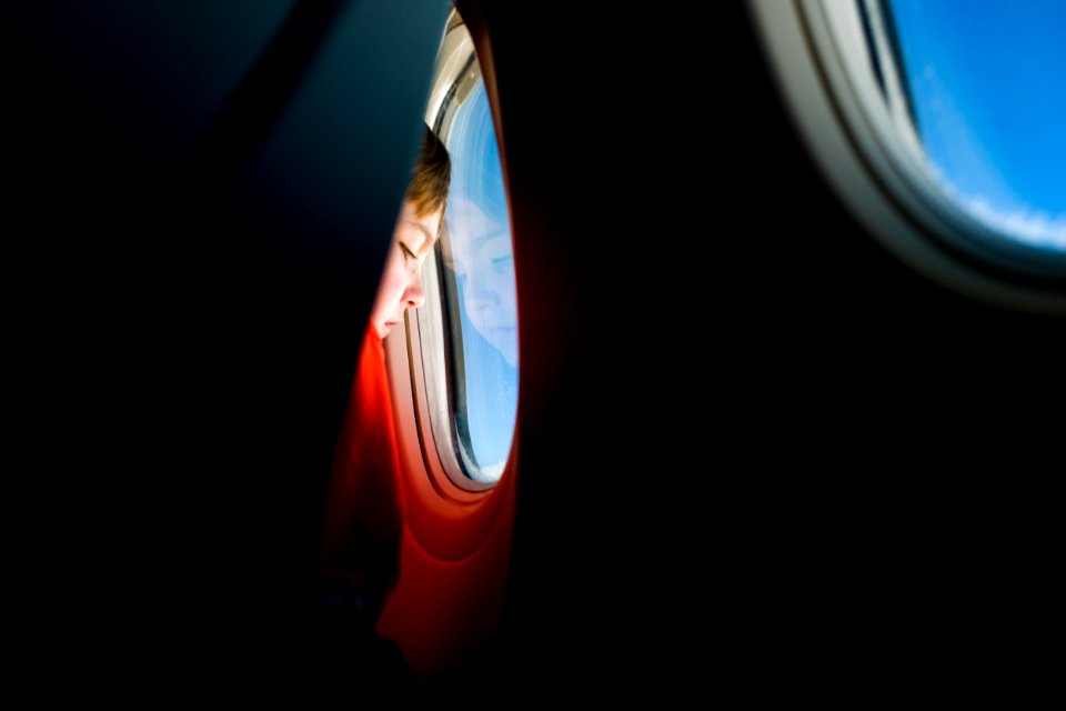 person looking at the window of an airplane