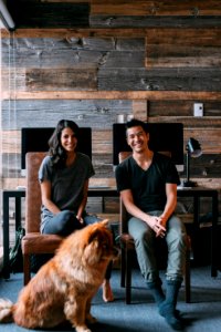 tan dog sitting beside man and woman