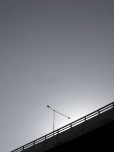 grayscale photo of bridge with postl ight photo