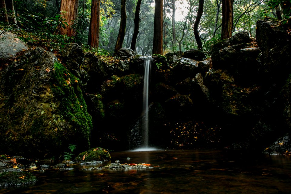 shallow focus photography of body of water surrounded by rocks