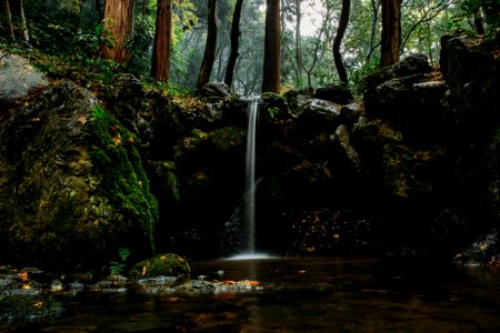 shallow focus photography of body of water surrounded by rocks