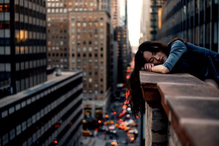 woman leaning on top building rail during daytime photo