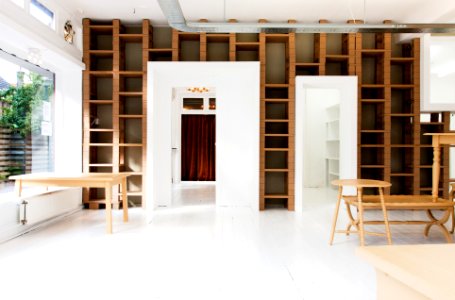 two beige wooden tables in white room
