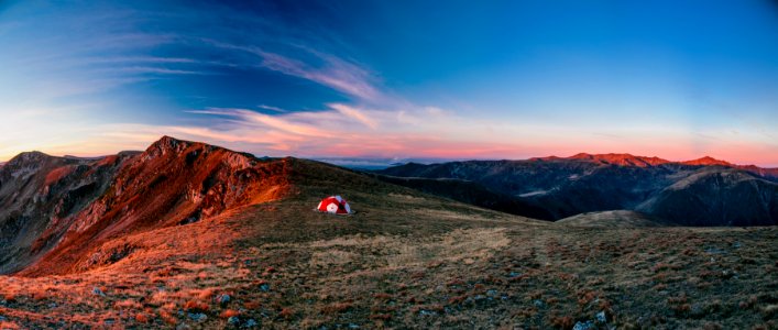 red and white camping tent on top of the mountain during daytime photo