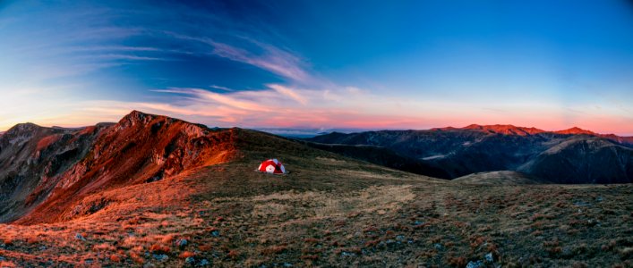 red and white camping tent on top of the mountain during daytime