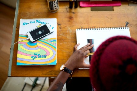 person drawing on white sketch pad
