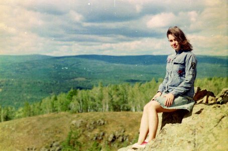 woman sitting on stone during daytime photo