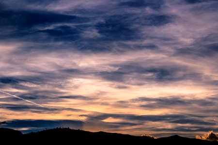 silhouette of mountains under blue and white cludy sky