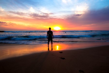 person standing on shoreline photo