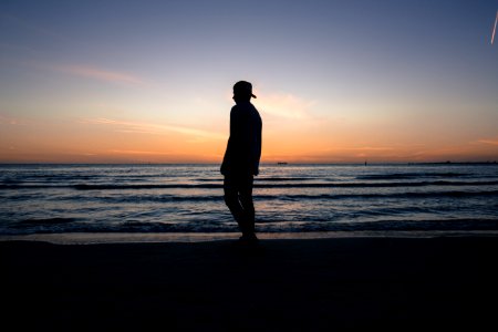 man standing on beach shore during daytime photo