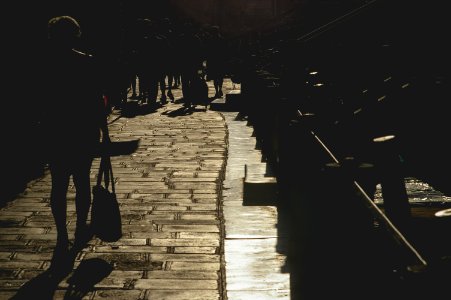 silhouette photography of woman passing through bridge photo