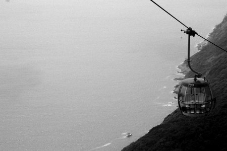grayscale photography of cable car distance with sea photo