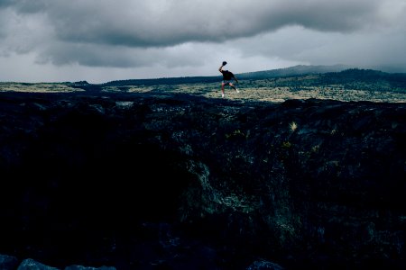 man standing on rock formation during daytime photo