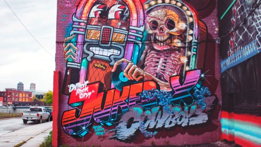 A painting of a jukebox and a skeleton, with the title "Jukebox Cowboys."