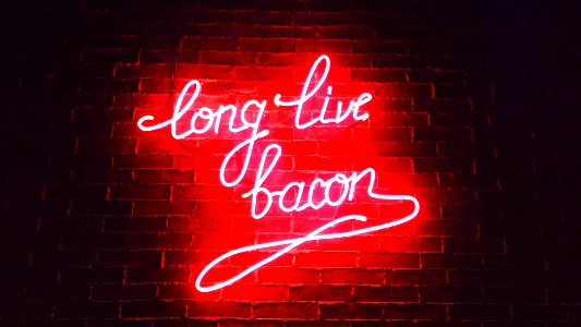 red ling live bacon neon light signage on brown wall bricks photo