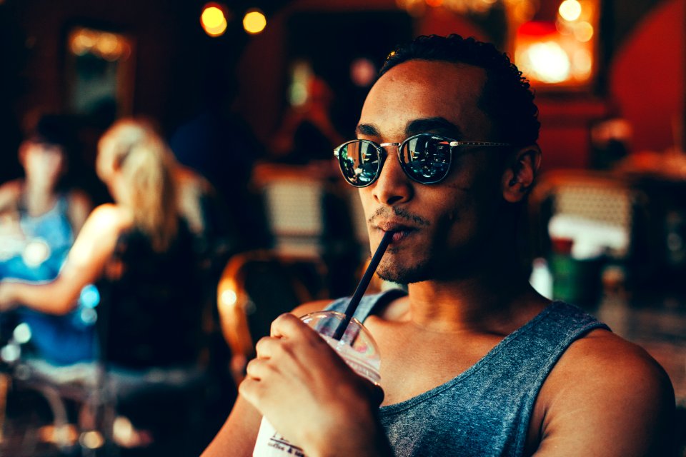 man sipping cooler while sitting on chair photo