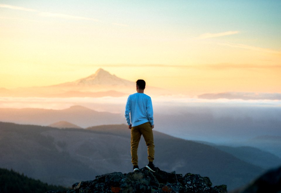man standing on top of mountain