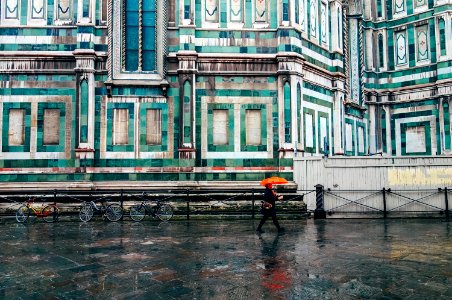 person holding umbrella walking on road photo