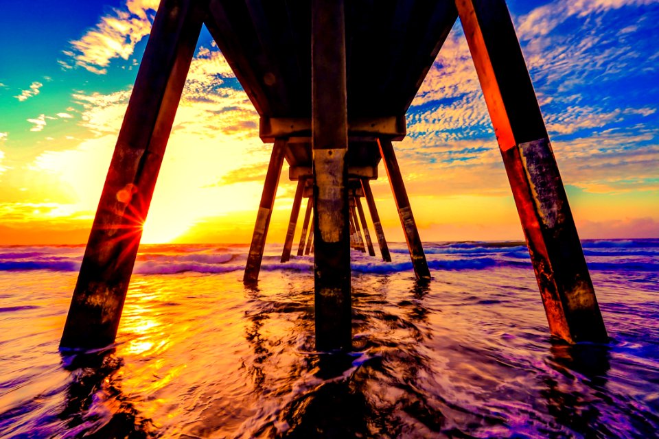 under view of brown wooden boardwalk during sunrise