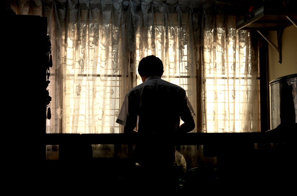 man wearing white collared shirt near window