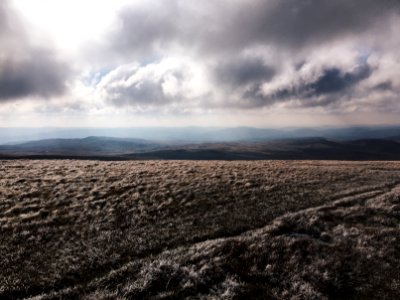 brown grass field near mountain under gray clouds photo