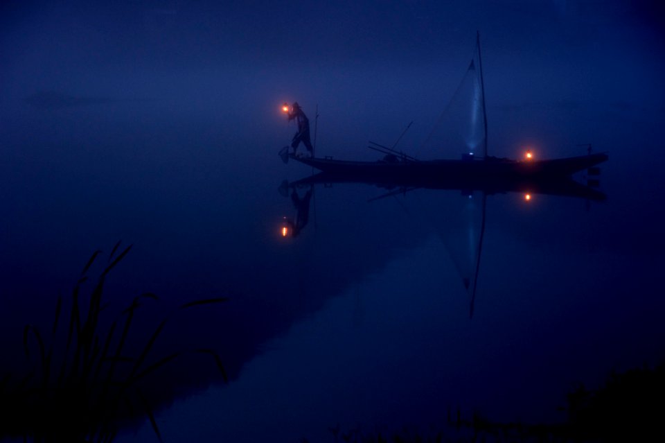 person on boat holding lantern