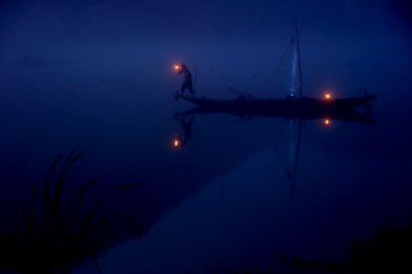 person on boat holding lantern