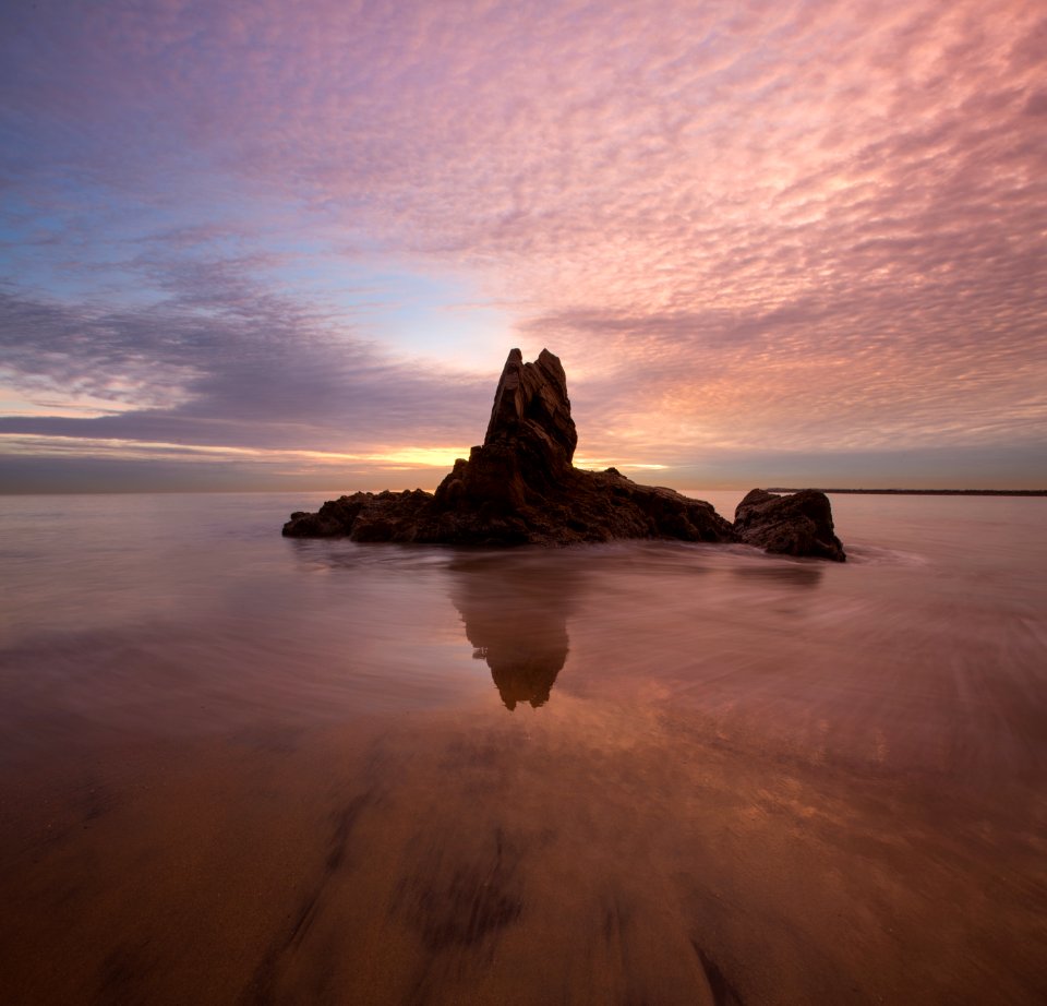 rock formation surrounded by water