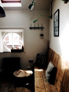 brown wooden bench beside white painted wall