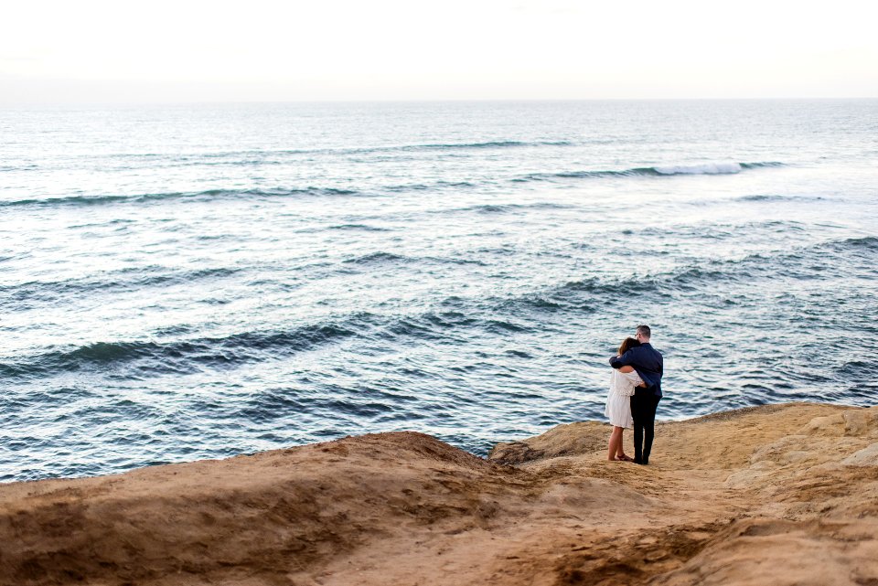 man and woman facing body of water