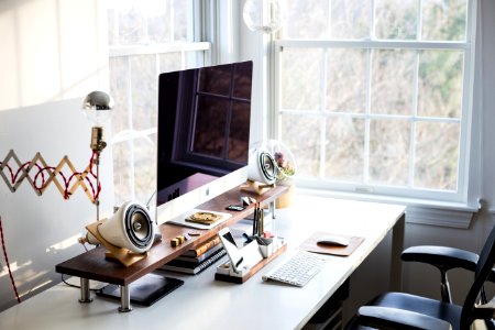 silver iMac on desk near window photo