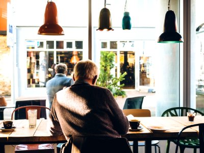man in chair with table beside coffee photo