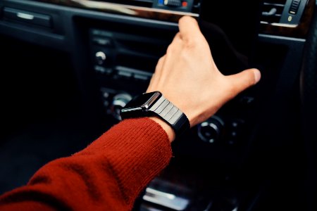 selective focus photography of person with smart watch driving car photo