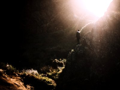 man standing on rock mountain during daytime photo