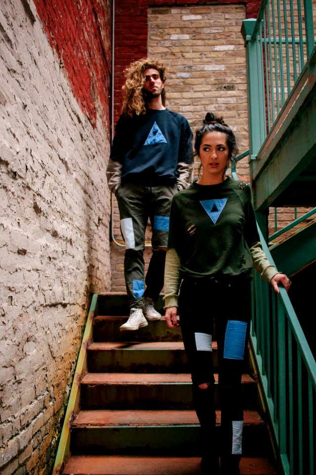 A young woman and a young man walking down the stairs in an old brick stairwell photo