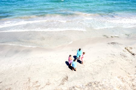 four people standing on seashore photo