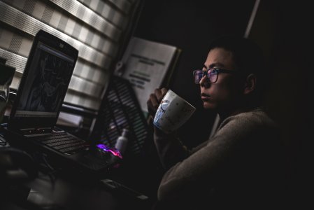 man holding mug in front laptop computer photo